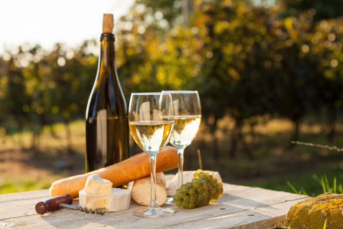 Two glasses of white wine and bottle at sunset shutterstock_156451127.jpg